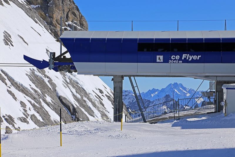 The blue top station of the Ice Flyer chairlift on a snow-covered ridge under a clear sky