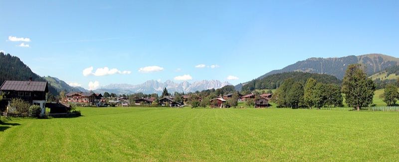 Panorama of Kitzbühel village with the jagged Kaisergebirge and Kitzbüheler Horn in the distance