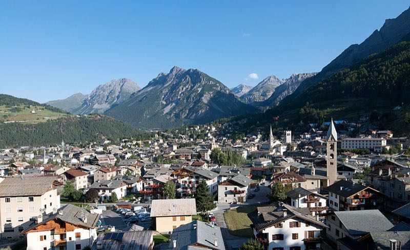 Elevated view of Bormio's rooftops and church towers with the Alta Valtellina mountains behind