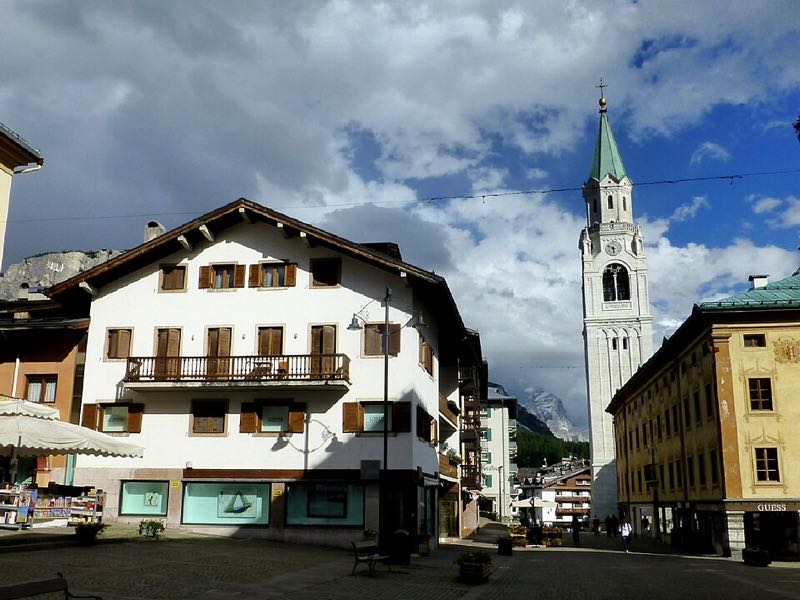 Cortina d Ampezzo town centre with its landmark bell tower and Dolomite peaks in the background
