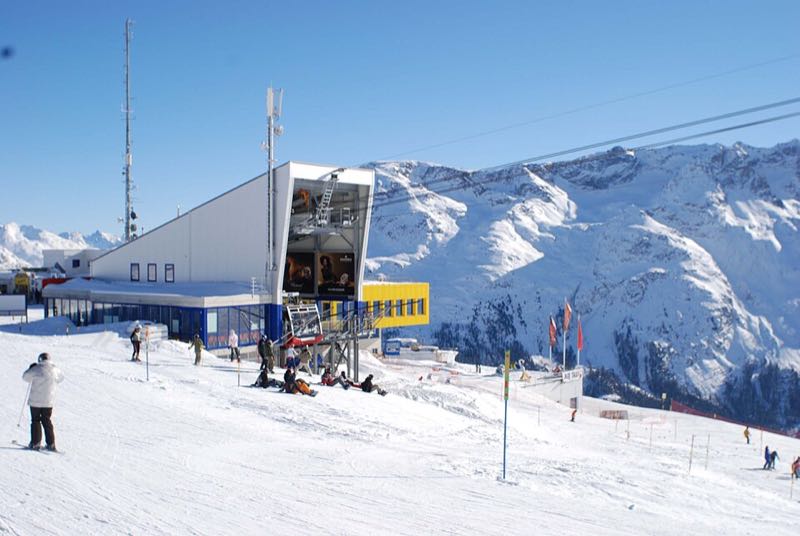 Skiers and a lift station on the snow at Corviglia above St. Moritz