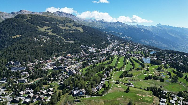 Crans-Montana on its sunny terrace above the Rhone valley, with the golf courses and the Valais Alps beyond