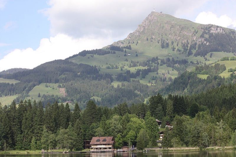 The Kitzbüheler Horn rising above green slopes and the Schwarzsee lake near Kitzbühel