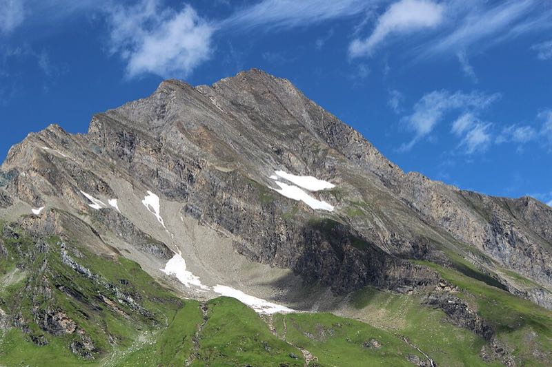 The Kitzsteinhorn peak and surrounding glaciated high alpine terrain under a blue sky