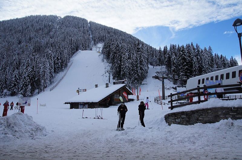 Skiers beside a chairlift station at the foot of the La Thuile ski area