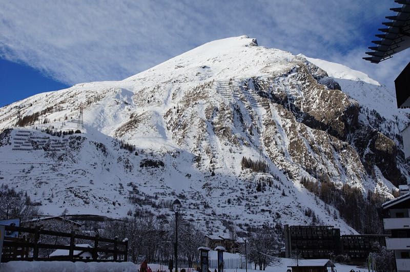 A snow-covered mountain rising above the rooftops of La Thuile