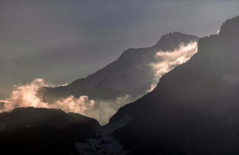 Dramatic snow-capped peak above Mayrhofen catching golden light through clouds