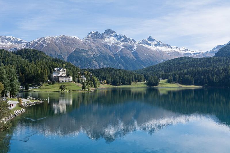 A still lake reflecting snow-capped peaks above St. Moritz