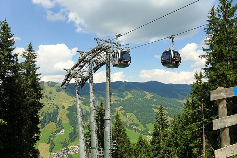 Schattberg X-Press gondola cabins over green mountains and the valley at Saalbach
