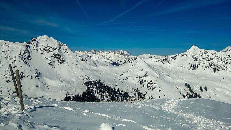 Winter panorama of snow-covered peaks across the Saalbach-Hinterglemm ski area under a deep blue sky