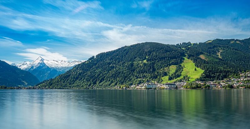 Calm Zeller See with the town on the shore and the snow-capped Kitzsteinhorn glacier beyond